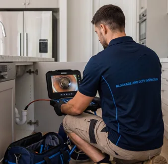 Plumber clearing a blocked toilet in a Yarrawarrah bathroom